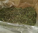 Open box lined with a clear bag and filled with dried grass.