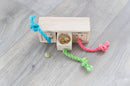 Trixie Snack Cube on a wooden floor with treats in the open centre drawer and colourful pull rope