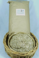  Brown paper bag behind a bowl of chopped flax bedding displayed in a wicker basket.
